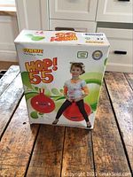 Boxed Hop 55 bouncy hopper ball for kids, brand new and unopened with child shown on packaging bouncing on the ball.