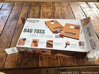 Photo of the unopened Mainstreet Mini Bag Toss Table Top Game box on a wooden surface with front and top views showing the product and contents.