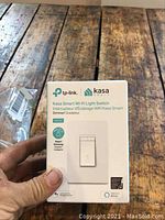 Front of box showing TP-Link Kasa Smart Wi-Fi light dimmer switch HS220 and compatibility logos
