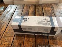 White box labeled 'TABLE SLICER' containing slicing device, unopened.