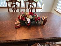 Full view of table top with floral centerpiece and two Santa figurines