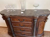 Buffet bar with marble top, four drawers, two side cabinets and displayed glassware