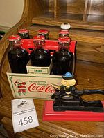 Photo of six Coca-Cola Christmas bottles in original holiday carton with nutcracker beside it