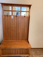 Full view of wooden hall tree storage bench with back, hooks and bench seat