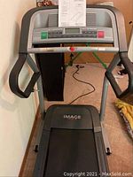 Front view of IMAGE 17.0 R treadmill showing the running deck and handlebars against a wall.