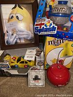 Lot overview including framed print, M&M Mocha Splash dispenser, red apple candy jar, and other M&M collectibles