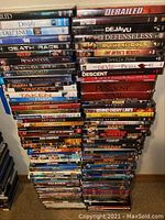 Pile of DVDs and Blu-rays stacked showing multiple titles including Derailed, Deeply, Resident Evil, Underworld collections