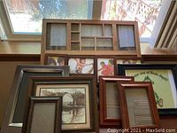 Image showing multiple wooden picture frames stacked with sepia barn artwork visible and bulletin board frame