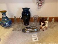Overview photo showing a collection of vintage glassware and ceramics including vases, salt and pepper shakers, and other decorative items.