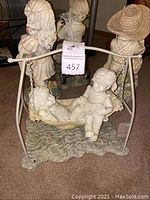 Five yard art figurines of children, including girl and boy on swing, girl with apple and basket, boy with tricycle and fishing rod, and two additional children figurines.