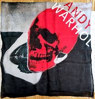 Full view of the bandana laid flat showing the red skull image overlaid on a black, white, and gray background with text details.