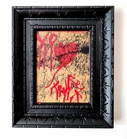 Straight-on view of front showing full composition: black scribbles, red heart motif and tag