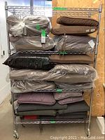 Shelving rack displaying all cushions in lot packed and stacked, showing brown and grey cushions mainly.