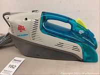 Side view of Dirt Devil Spot Scrubber showing branding, translucent blue handle, and gray power cord coiled behind