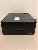 Front view of black food dehydrator showing pull-out tray and timer dial on top right corner.