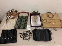 Full view of assorted women's fashion accessories including handbags, belts, and pouch arranged on table.