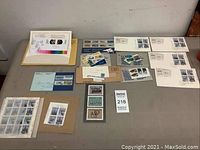 Complete view of the collection spread on a table showing multiple sets of Canadian stamps, first day covers, and mounted items mainly from the 1980s.