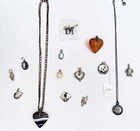 Full lot of 14 pendants displayed on white surface including heart, turtle, amber, and gua pendants