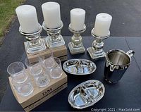 Full lot showing pillar candles on candle holders, glasses in boxes, serving trays, and ice bucket.