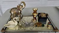 Top view of the brass perfume tray holding various decorative items including the elephant figurine, glass bowl, vase, and boxes
