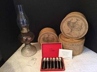 Photo of all five items in the lot together: oil lamp, 3 nesting boxes, and red box with 6 spoons inside