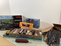 Wide view showing Märklin Mini-Club box, MRC controller box, Athearn car boxes lined up and loose track pieces