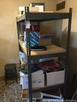 Full view of shelving unit loaded with various boxes and items, showing metal frame and wooden shelves.