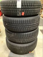 Stack of four mounted tires showing tread pattern and quantity