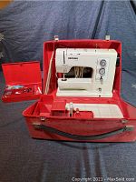 Bernina Record sewing machine and red case open with removable accessory box next to it