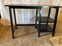 Front view of black computer desk showing two shelves on the right side and simple frame