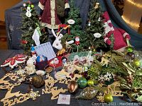 Full display of the lot showing the large pre-lit Christmas tree, mini trees, fabric snowman figure, wooden 'Peace' reindeer ornaments, glass and fabric ornaments, decorative ribbon, and platters.