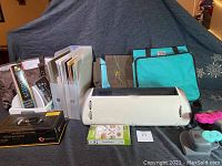 Full view of all items laid out including Cricut Expression machine, bags, punches, paper punches, and papers, with Team Spirit cartridge visible.