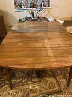 Overhead view of full table top showing removable leaf installed, wood grain and surface wear