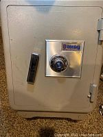 Front view of gray Sentry safe with combination lock dial and handle on door showing overall condition.
