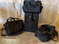 Black Swiss Army 20-inch roller suitcase, briefcase, and square duffel cosmetic bag shown together on carpet.