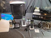 Various electronic items including cordless telephones, HP printer, shredder, router, security wipes and cables.
