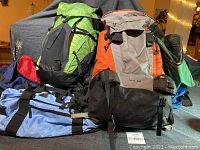 Photo of multiple backpacks and duffel bags showing condition and colors