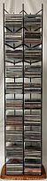 Full view of metal CD stand with multiple shelves holding many CDs stacked vertically, showing the overall setup and quantity.