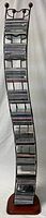 Full view of the metal CD stand holding multiple rows of CDs, curved shape with wooden base