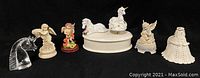 Full view of all 7 figurines including 2 music boxes, 4 angel/unicorn statues, and glass unicorn head