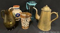 Five assorted beverage jugs and decanters in one photo showing overall condition and variety