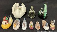 Front view of 10 assorted duck and bird figurines in various materials and sizes displayed on black background.