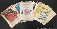 A large assortment of vintage sheet music featuring military songs and classics with visible age wear and illustrated covers.