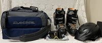 Dakine ski bag filled with ski boots, ski goggles, snowsuit, and helmet visible outside the bag.
