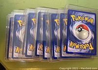 Stack of Pokémon cards, backs showing, in plastic sleeves