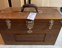 Front exterior view of quarter-sawn oak toolbox with leather handle, central latch and side catches