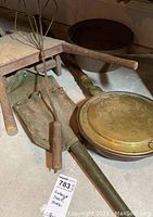 Image showing military folding trench shovel, brass bed warmer with floral embossing, and wire rug beater with wooden handle