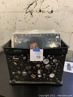 Black plastic crate containing over 50 vinyl records from various genres with covers partially visible.