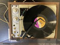 Top view of the KLH turntable with a vinyl record on the platter showing control dials and tonearm.