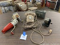 Photo showing the rotary phone, pencil sharpener, and two ice grinders on a table.
